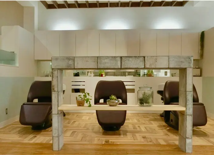 木目の床と観葉植物が置かれたナチュラルテイストのシャンプー台スペース