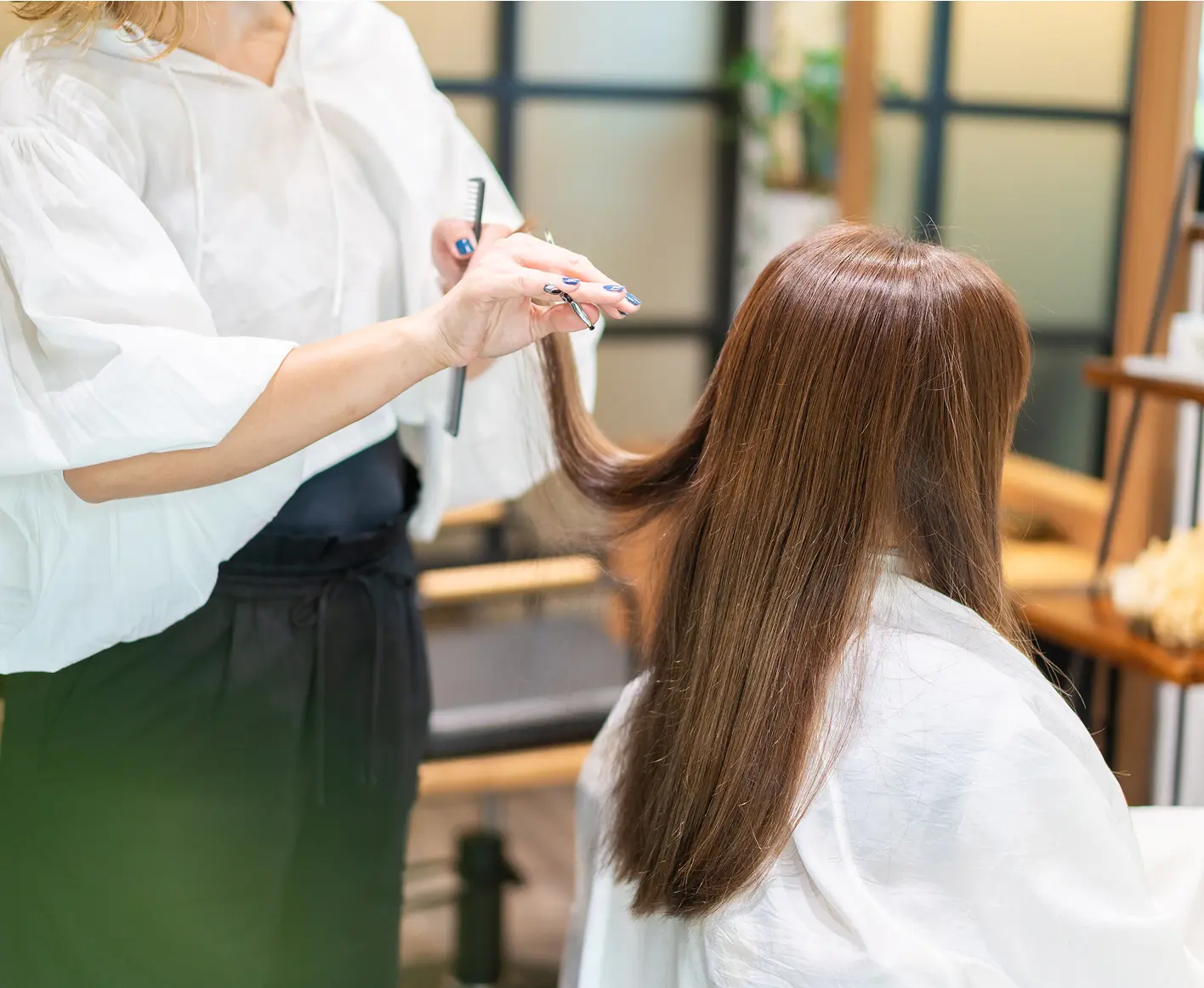 美容室で髪を切っている女性
