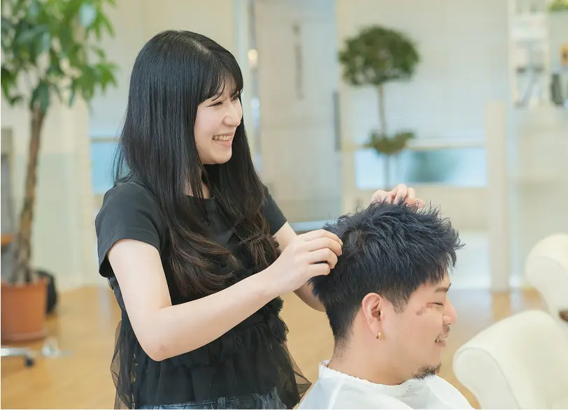 女性スタイリストが男性客を施術している様子